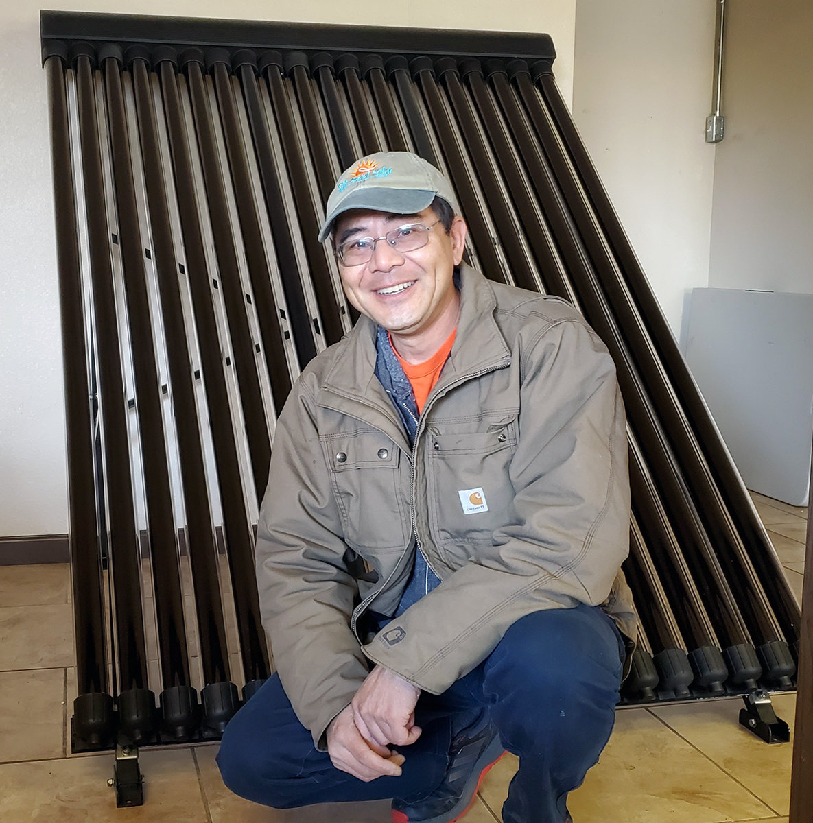 Silk Road Environmental owner Ray Lam stands in front of one of his custom-designed solar hot water heaters.