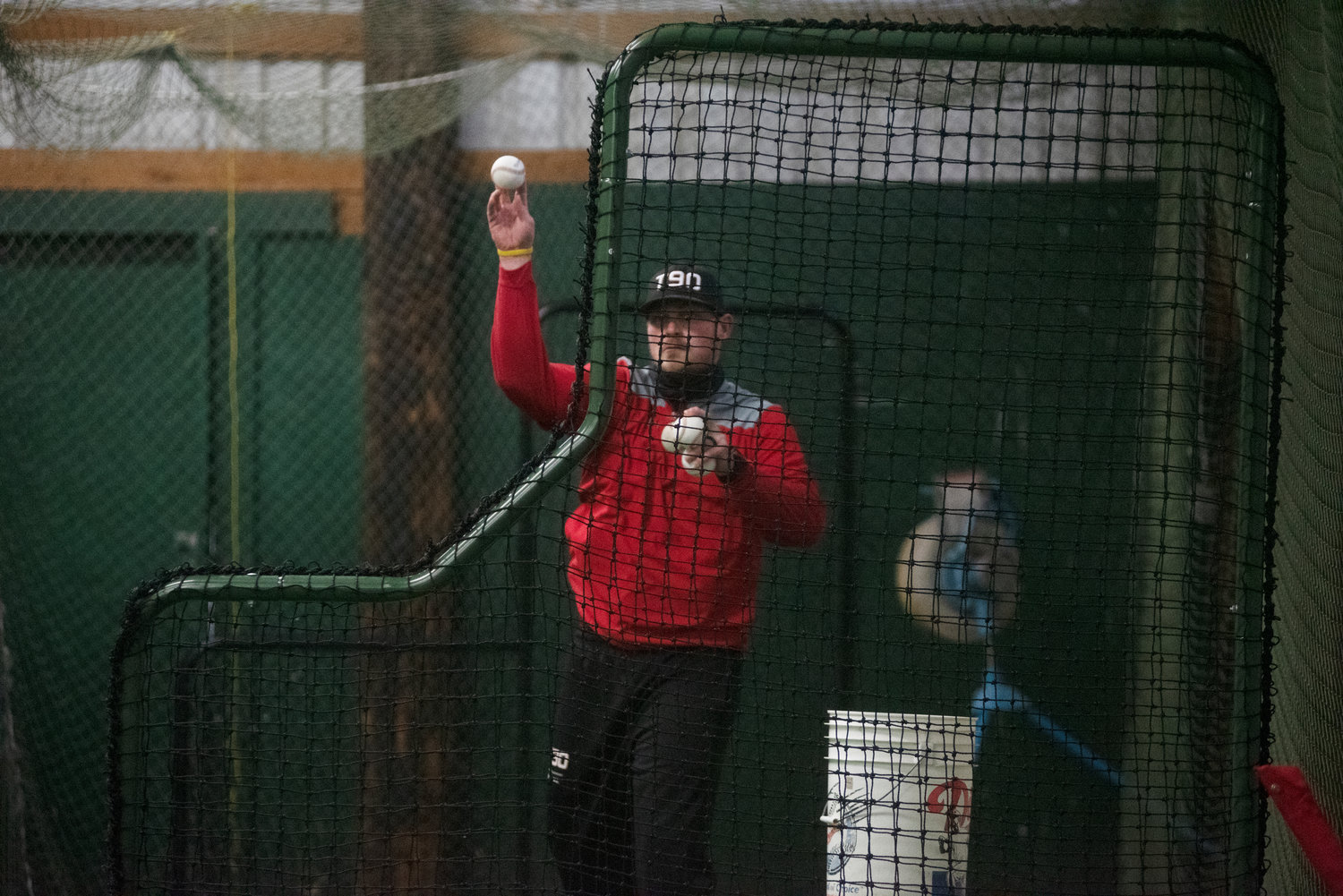 Tenino coach Ryan Schlesser throws pitches to his players in the Beavers’ batting cage on Nov. 4.
