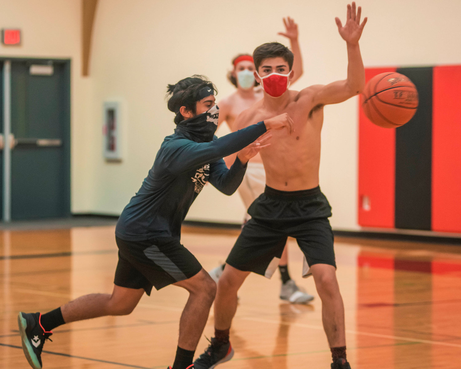 A player sports a neck gaiter as he passes the basketball during practice at Mossyrock High School on Sunday.