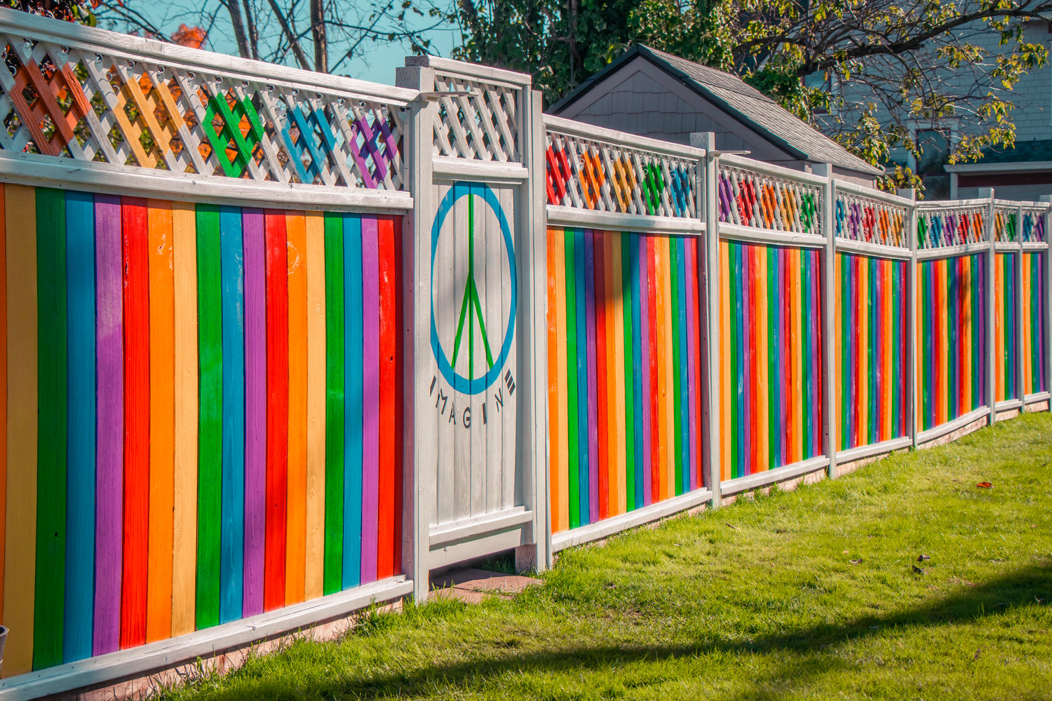 A stretch of fence is painted with rainbow colors and a peace symbol along NW Pennsylvania Ave. in Chehalis.
