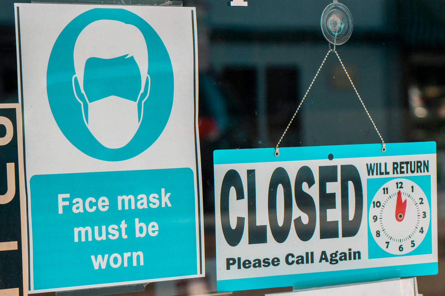 A sign requiring face masks before entering hangs on display next to a ‘closed’ sign last June in Chehalis.