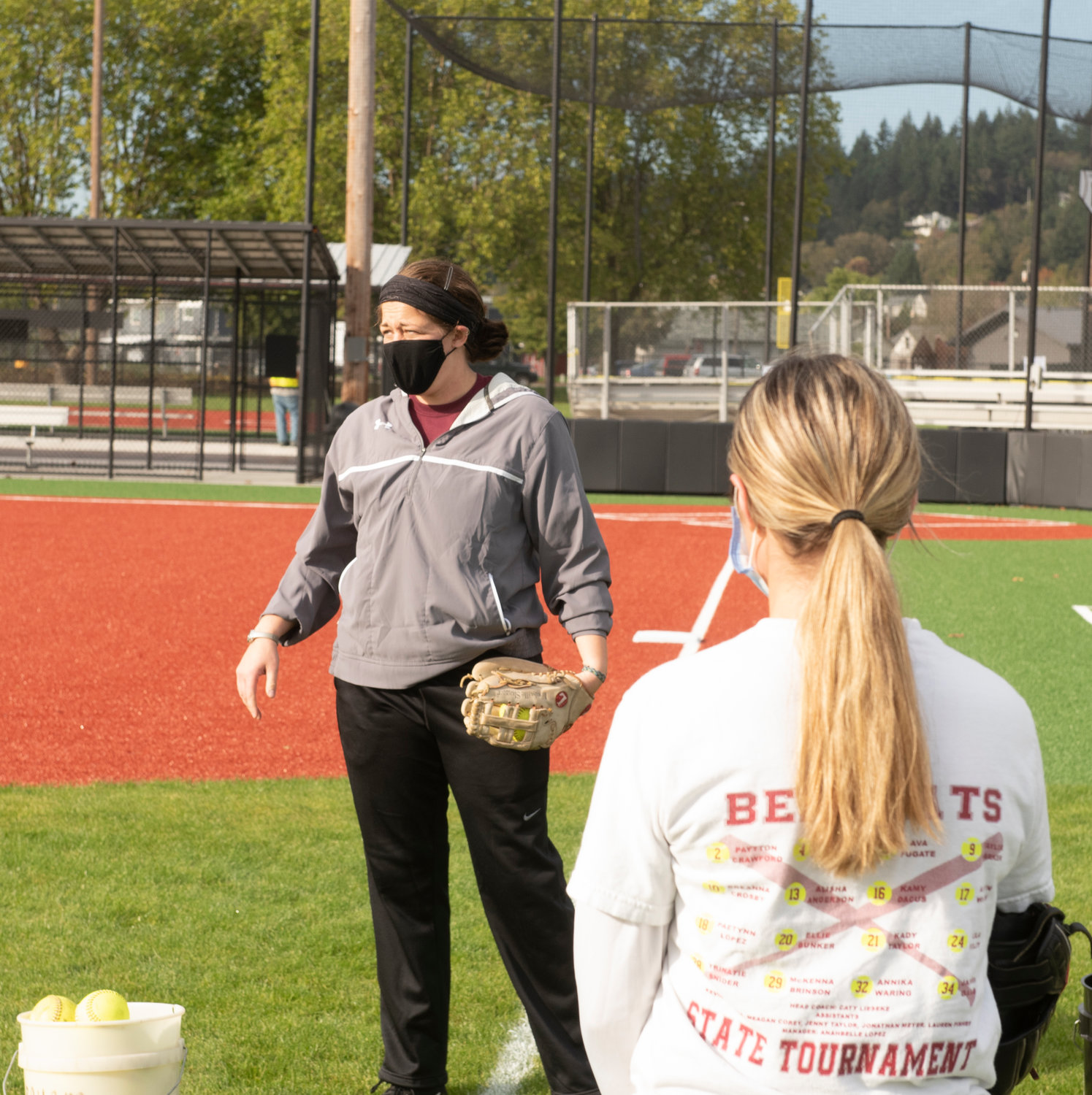 W.F. West softball coach Caty Lieseke, background, talks to a pod of six players during practice on Monday.