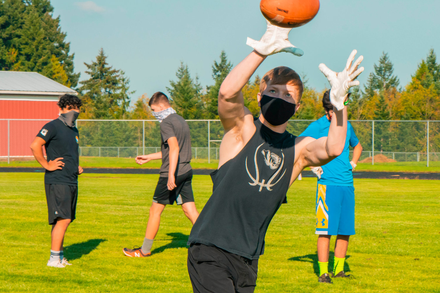 Players sport masks while catching footballs Wednesday afternoon at Napavine High School.