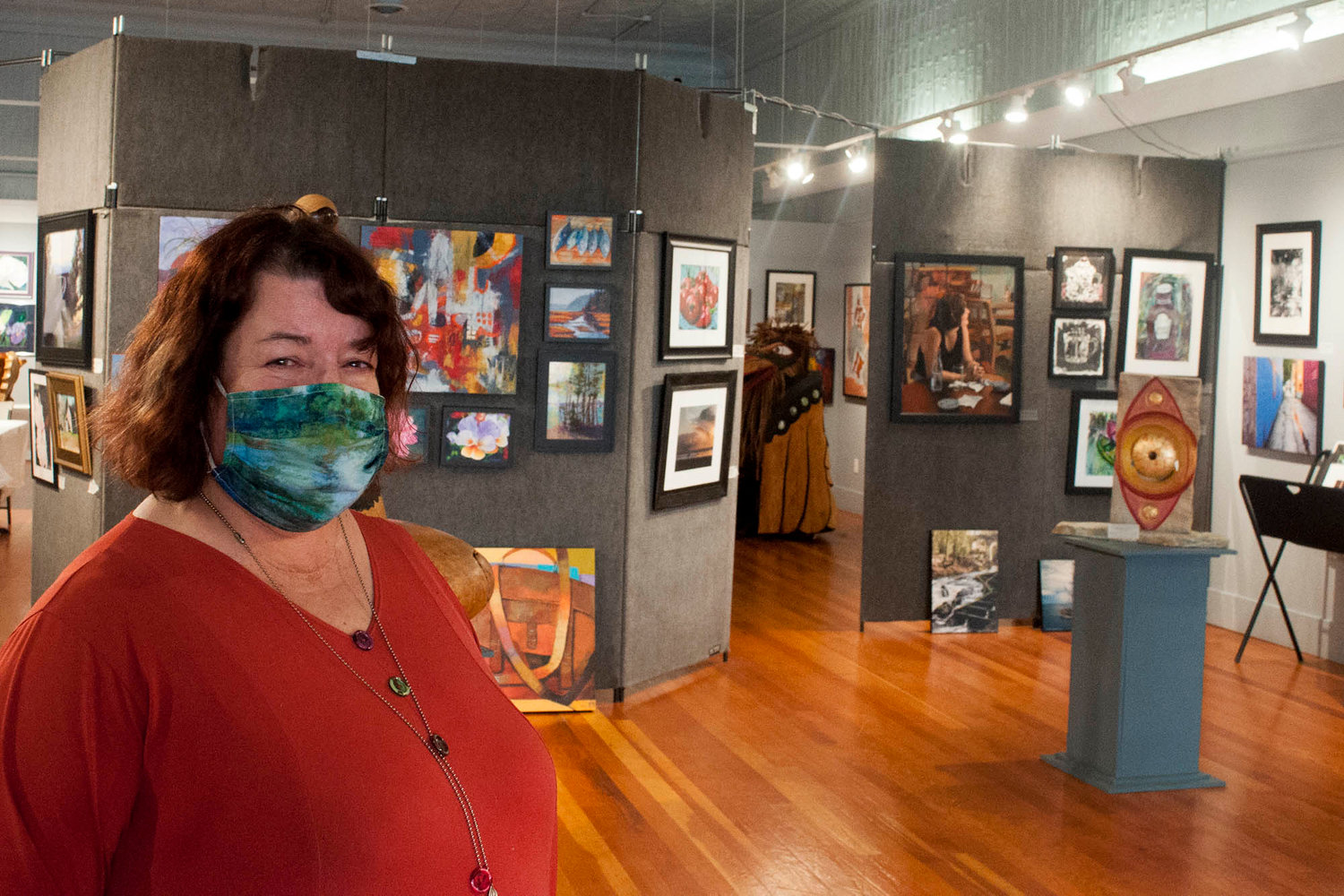 Jan Nontell, owner of Rectangle Gallery, stands in front of art work from local artsits.