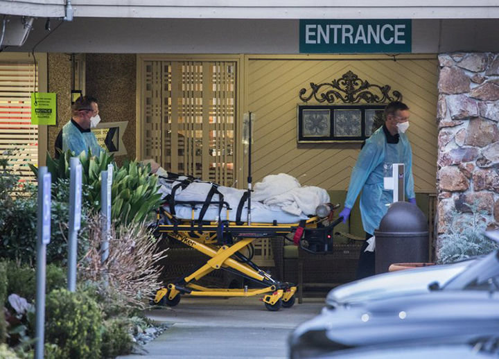 Emergency personnel wheel a resident out of Life Care Center of Kirkland, Thursday, March 5, headed for a hospital.