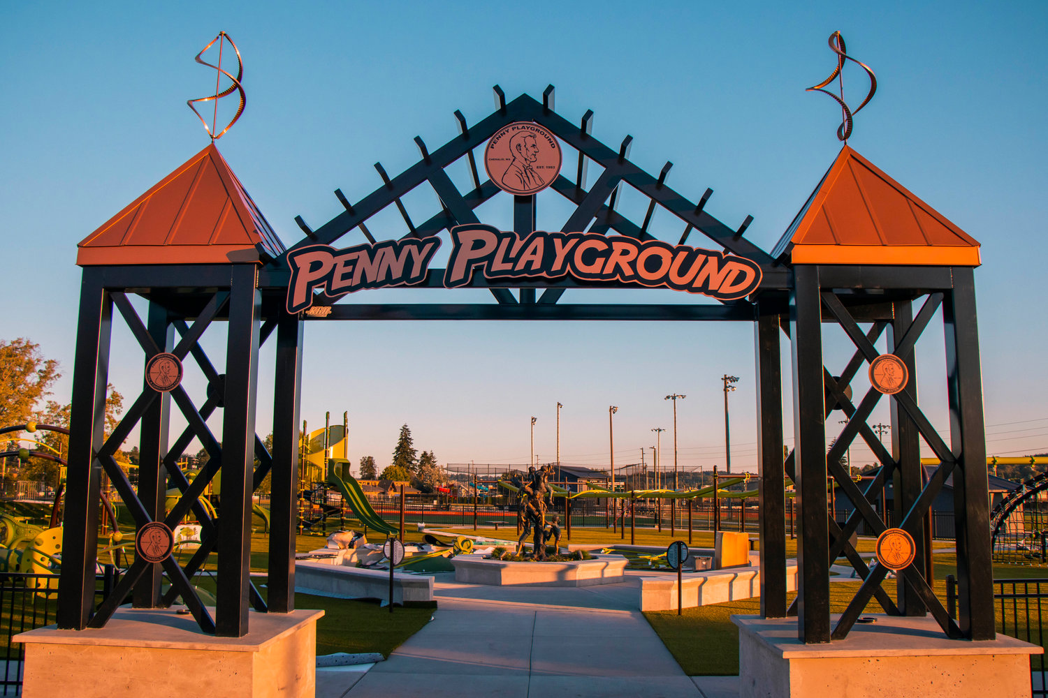 The Penny Playground sign beacons over SW William Ave. Tuesday evening in Chehalis.
