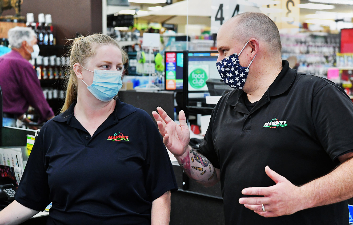 Chris Hamilton, right, manager of Tenino Fresh Market, chats with cashier Nicole Scibelli on Wednesday, June 24. Hamilton said he'd received wooden scrip from about five customers since the program began.