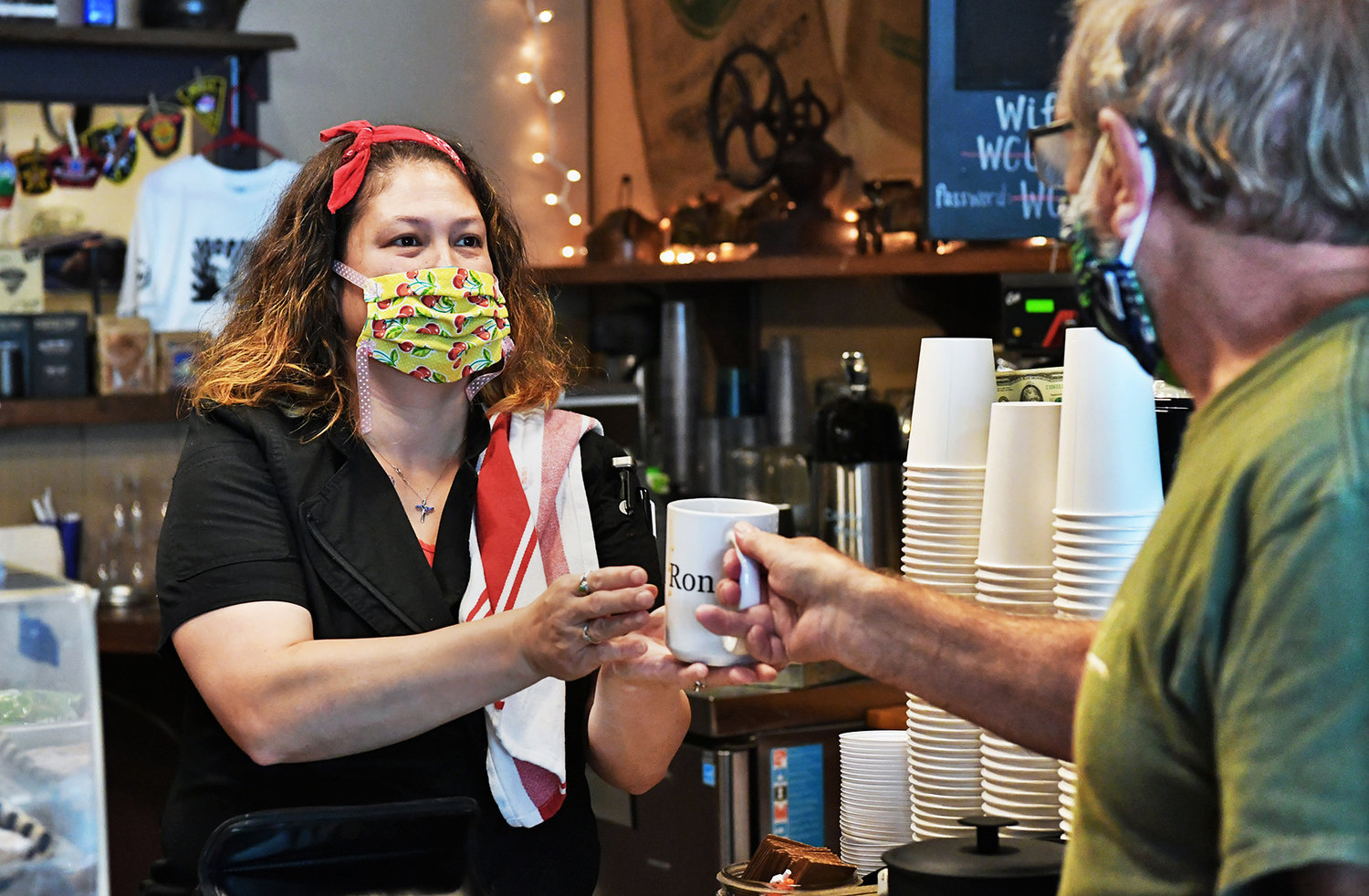 Maria Williams, owner of Tenino Coffee Bistro, has fielded seven calls recently from people as far away as New York seeking to purchase wooden scrip for up to $300 per $25 card. She has had no customers purchase any merchandise using the scrip, she said. Here she serves coffee to Ron Pemfield, 70, one of her regular customers.