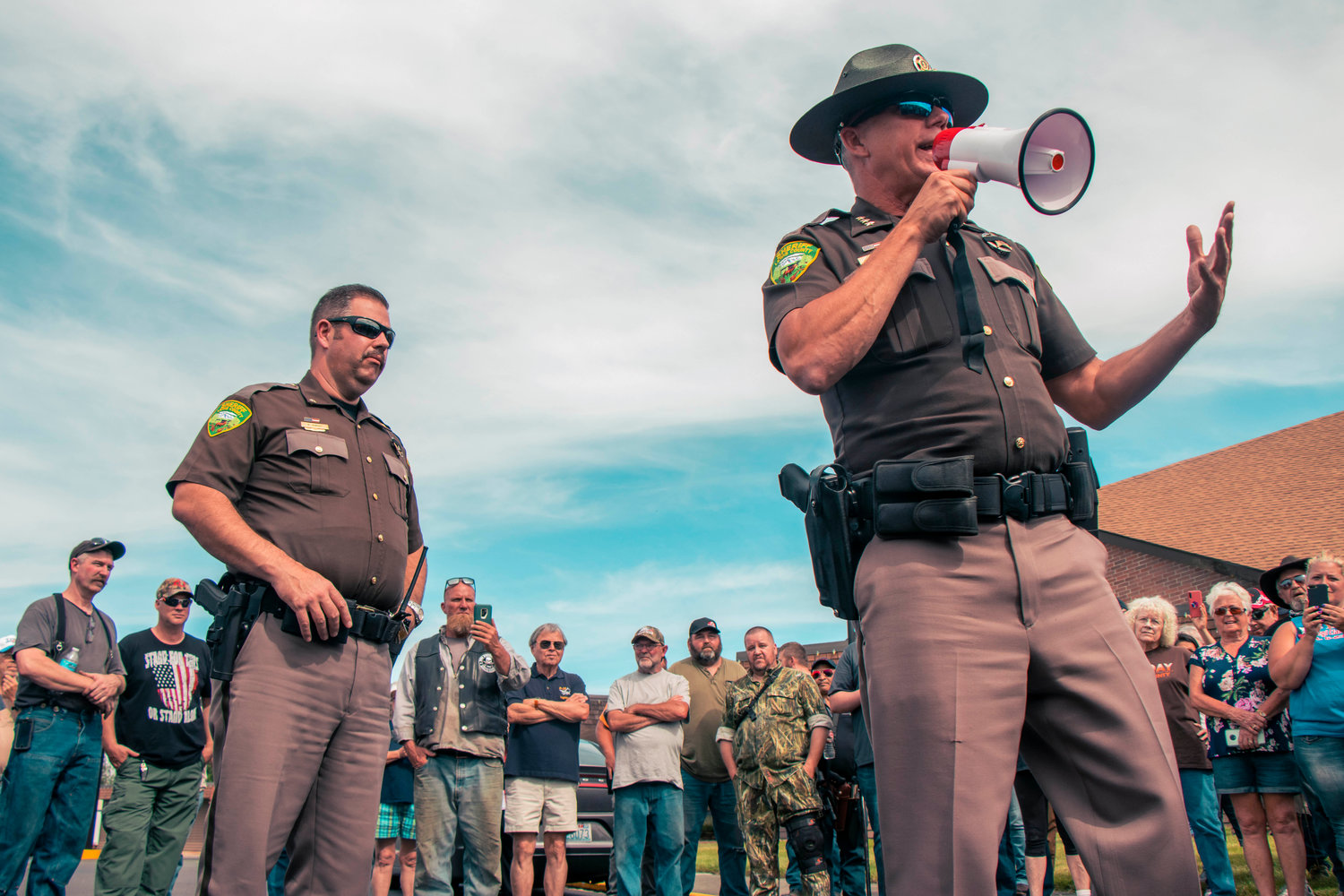 Sheriff Rob Snaza speaks with a microphone to Hamilton sign supporters in the parking lot of Bethel Church Tuesday afternoon in south Chehalis.