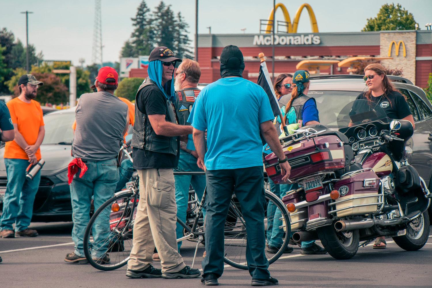 Hamilton sign supporters mingle in the parking lot of Bethel Church Tuesday afternoon in south Chehalis.