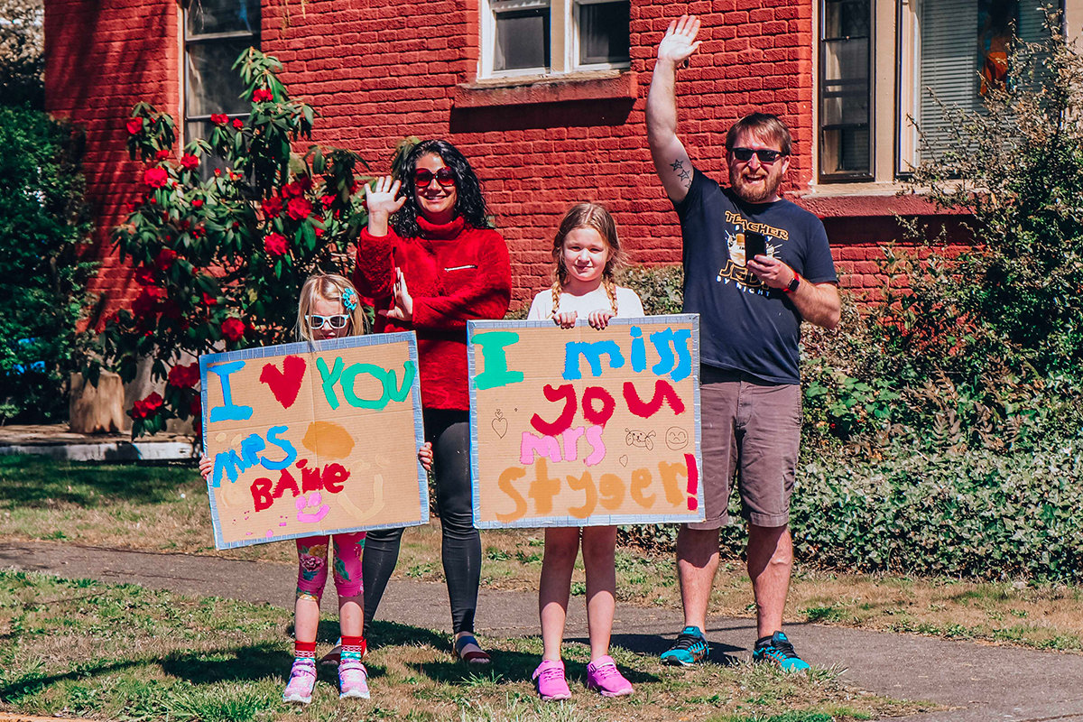 Families wave to teachers driving through the Edison district during a neighborhood parade last April in Centralia.