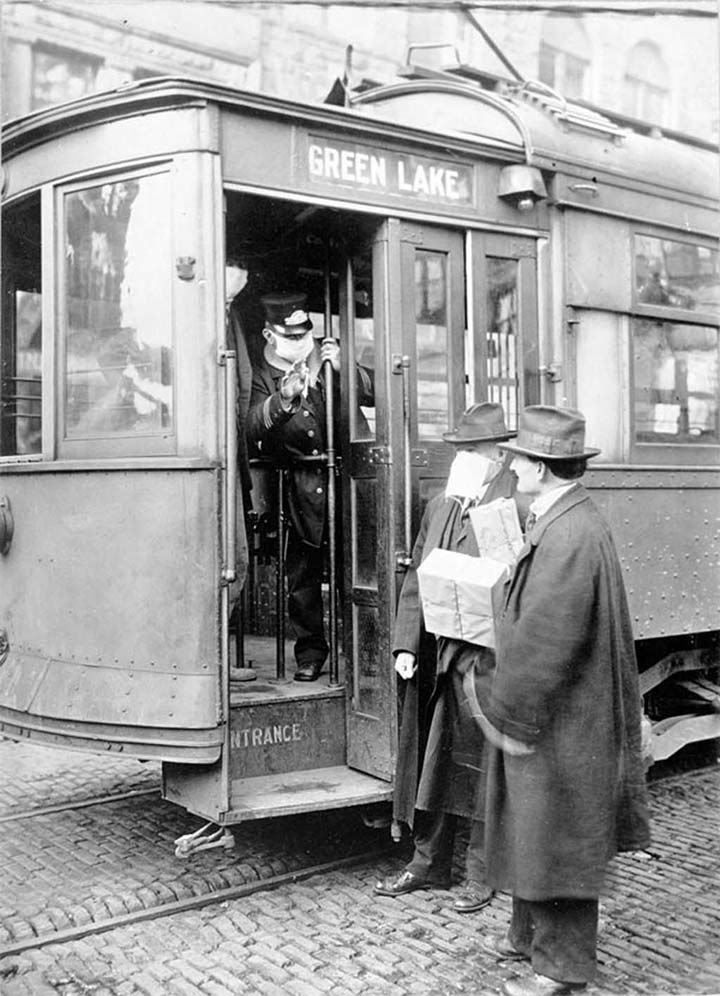 Streetcar conductor blocking entry of unmasked man during flu pandemic, Seattle, 1918