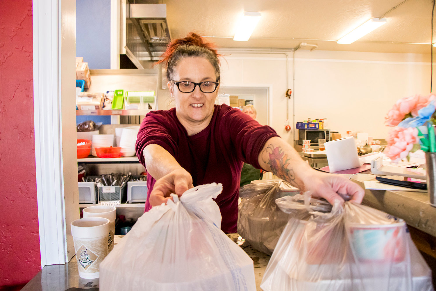 Bethanne Jones, Cafe Manager at Gather, sets up to-go meals Monday afternoon in Centralia.