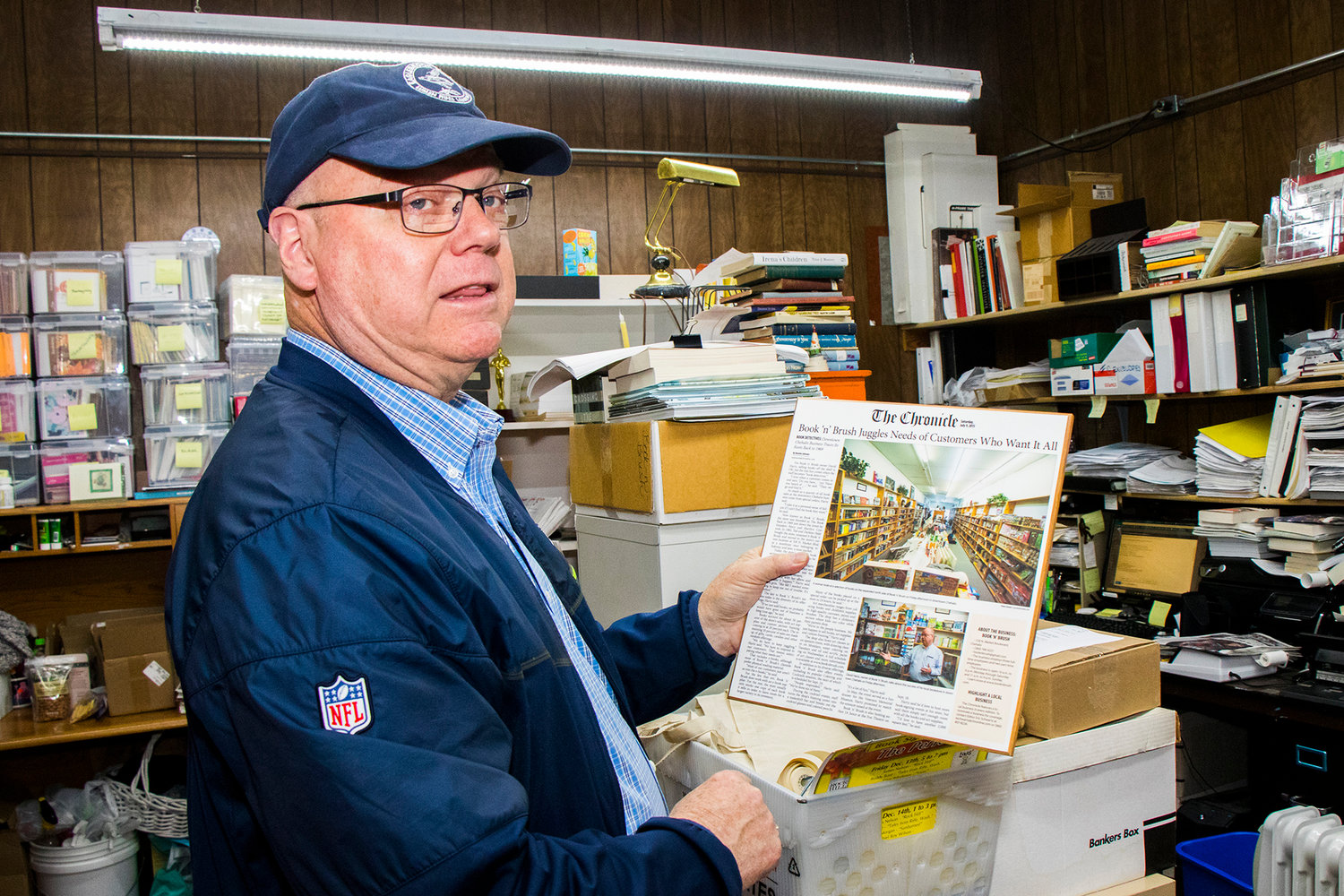 Owner David Hartz talks about a Chronicle Keepsake on display inside Book 'N' Brush Friday afternoon in Chehalis.