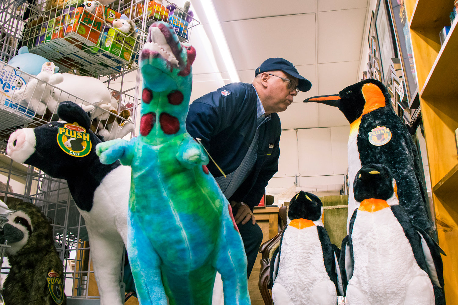 Owner David Hartz looks eye-to-eye with a stuffed penguin inside Book 'N' Brush Friday afternoon in Chehalis.