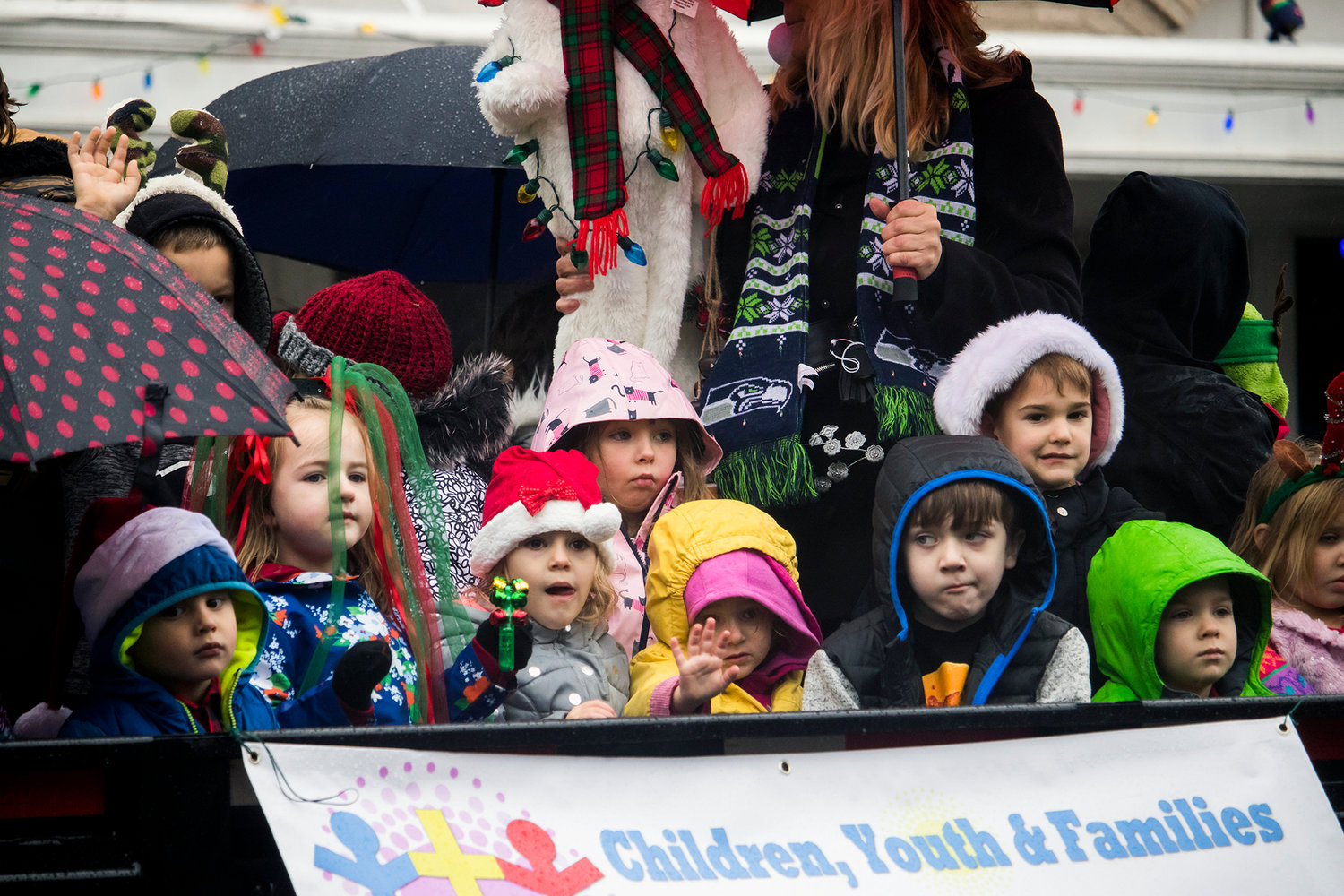 Kids wave to crowds from a float during the annual Santa Parade Saturday morning in downtown Chehalis.