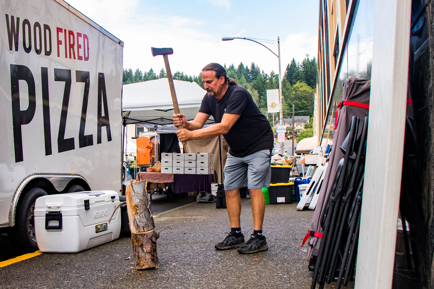Brent Yerton chops wood on the sidewalk of NE Boistfort Street, for the Milltown Pizza food cart Tuesday afternoon in Chehalis.