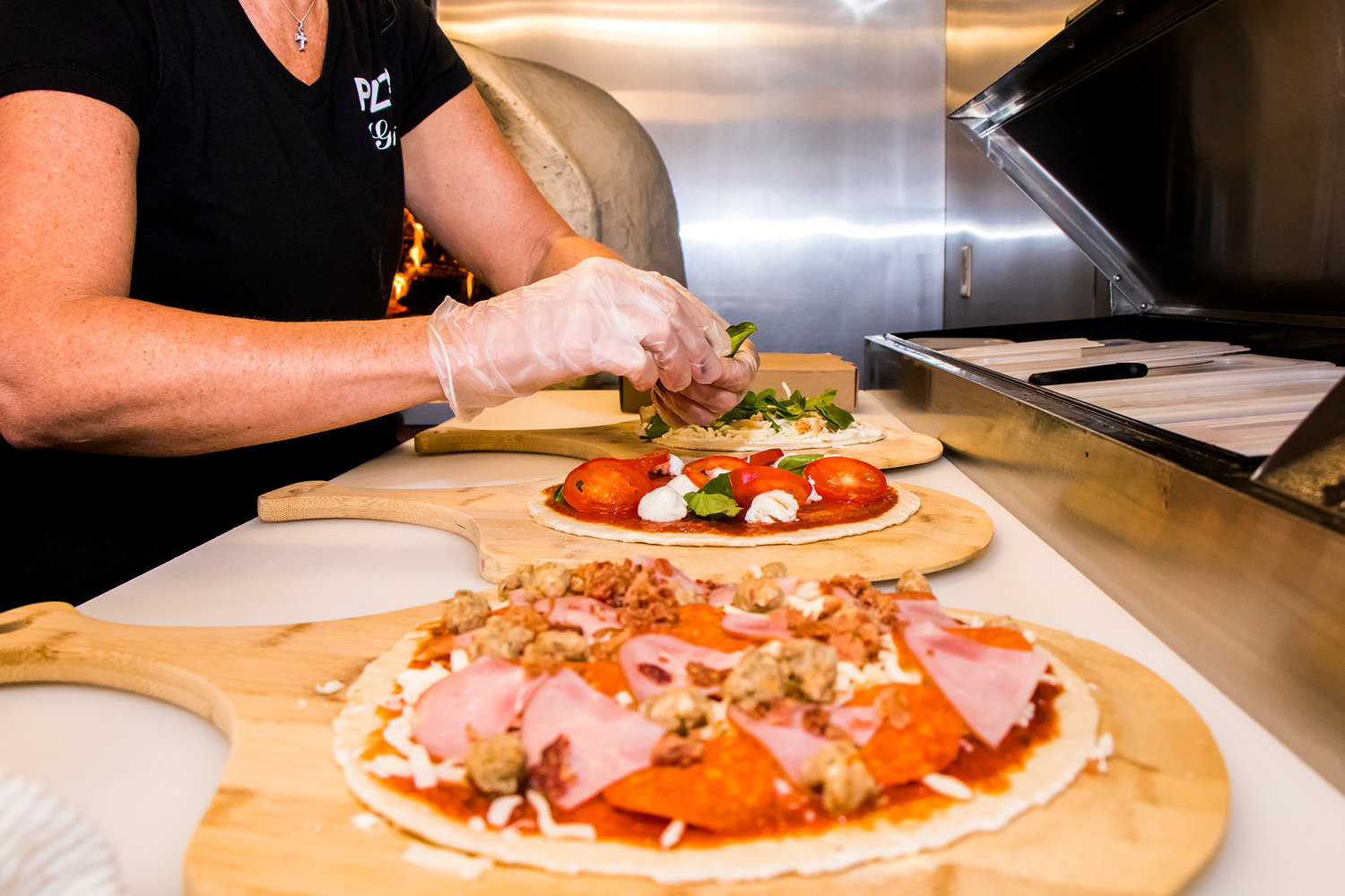 Starr Yerton prepares three pizzas at once, inside the Milltown Pizza food cart Tuesday afternoon in Chehalis.