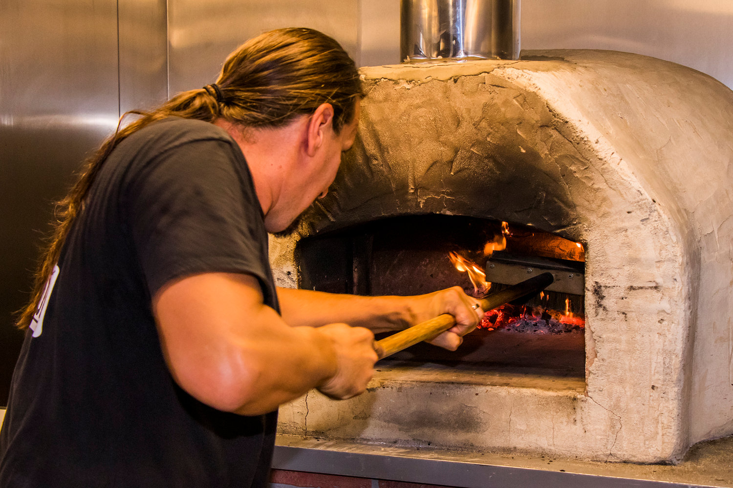Brent Yerton sweeps the floor of the oven inside the Milltown Pizza food cart Tuesday afternoon in Chehalis.