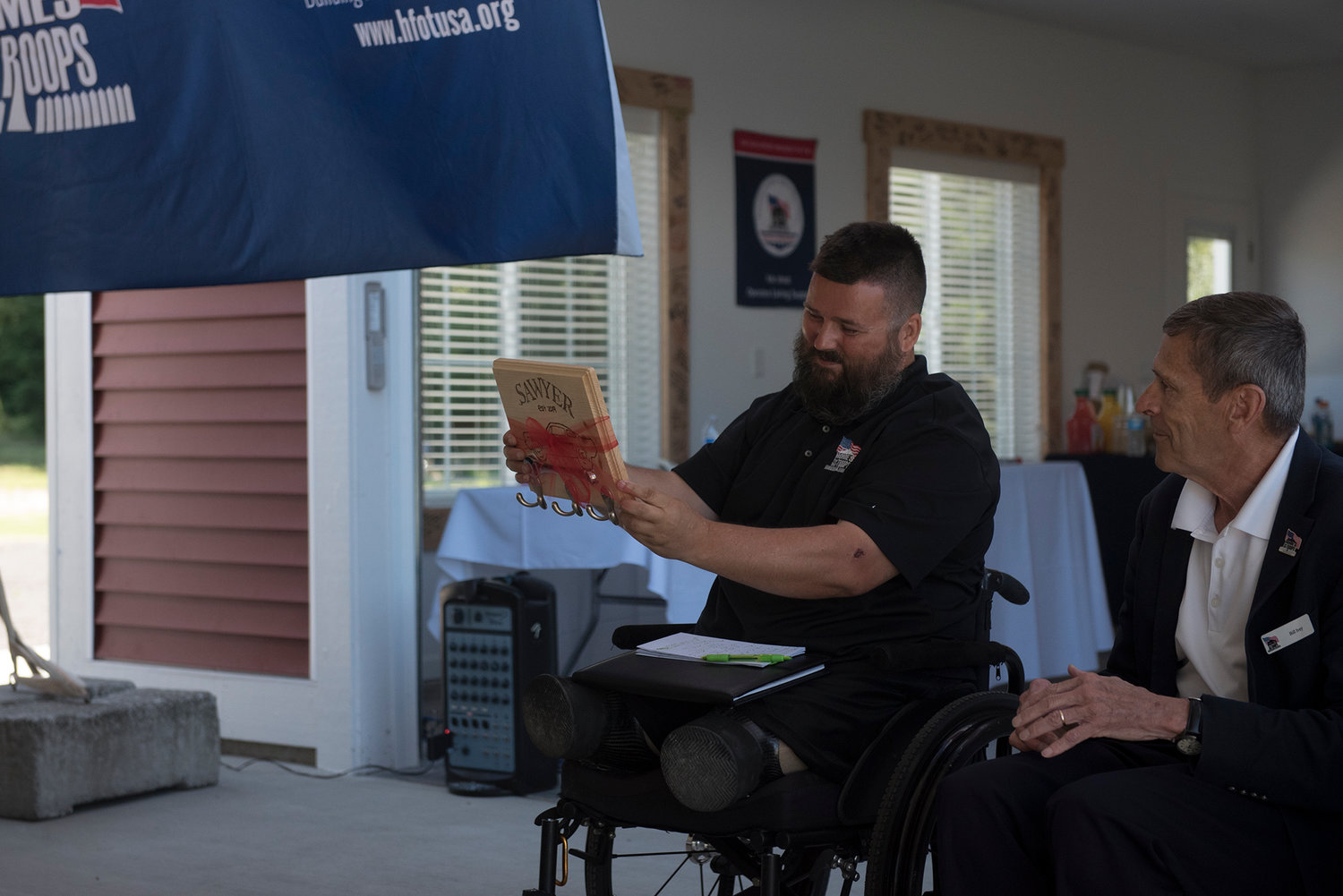 U.S. Army Sgt. Jereme Sawyer, left, shortly after being presented a key rack for his new home in Tenino by Homes For Our Troops Executive Director Bill Ivey, right.