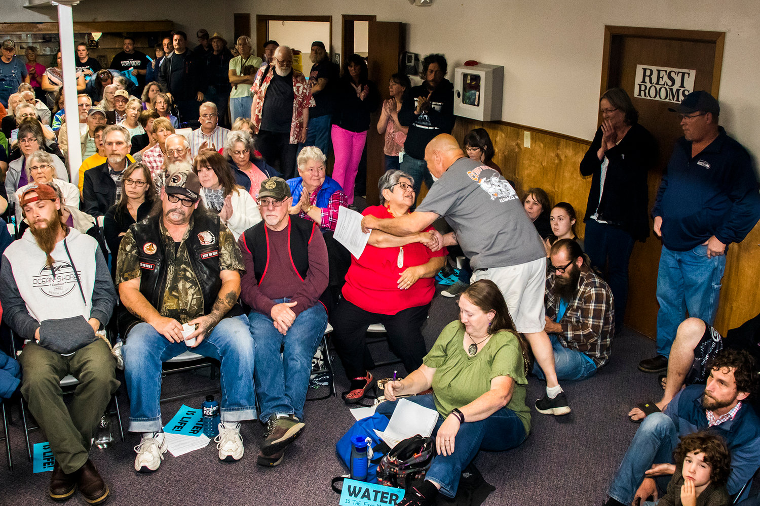 Greg King, vice president of Friends of the Cowlitz, a fishing advocacy group, greets members of the Cowlitz Tribe at a town hall event in Randle opposing a proposed water bottling plant.
