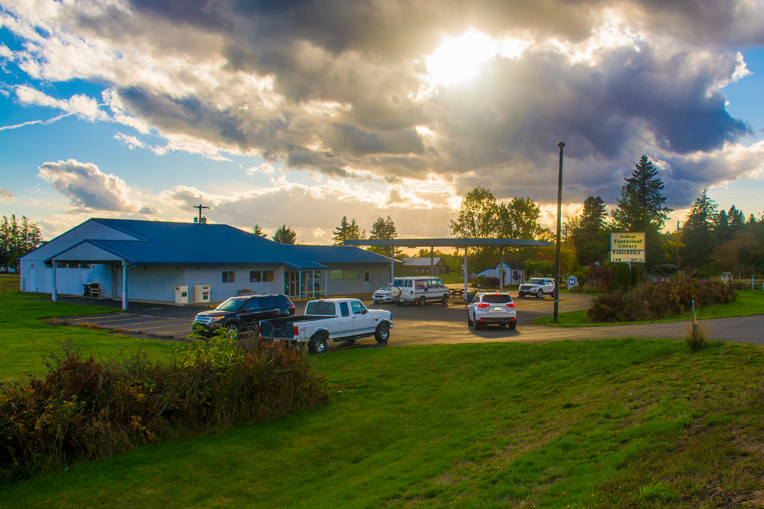 Cars sit in the parking lot of the Salkum Timberland Library, which has already closed for the day, connecting to one of the few WiFi Internet connections available in rural East Lewis County in this May 2019 Chronicle file photo. 