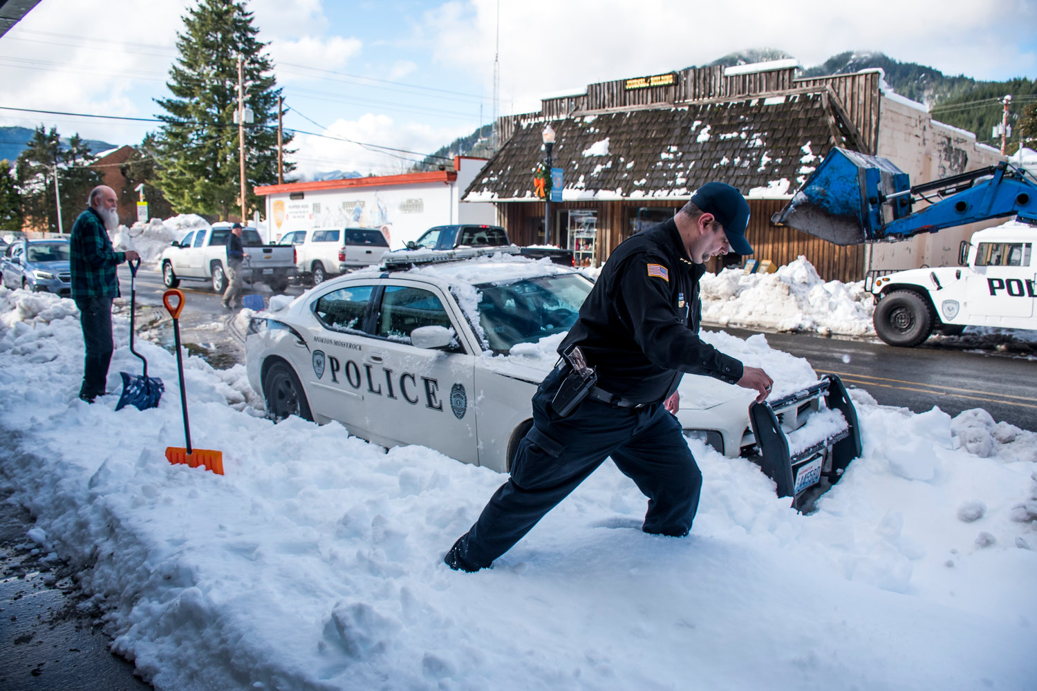 Community members help Chief Roger Morningstar remove his police cruiser from the snow Wednesday afternoon in Morton.