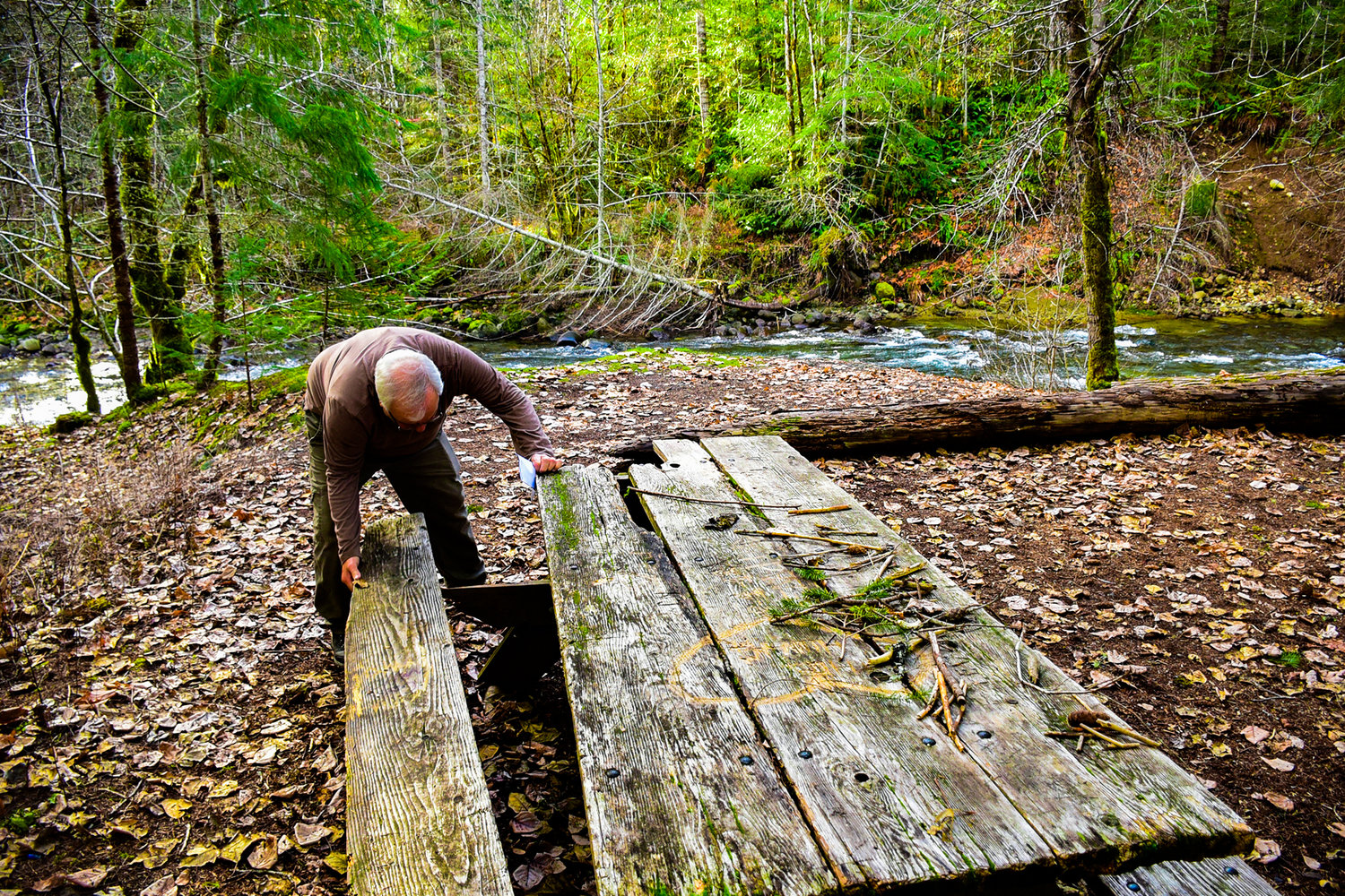 Bill Serrahn replaces a board on an old picnic table in Washington State Parks property in Packwood.
