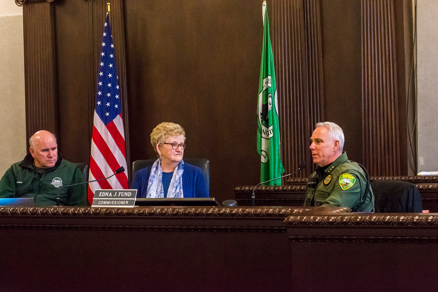 Lewis County sheriff Rob Snaza, right, speaks on Initiative 1639 as commissioners Gary Stamper and Edna Fund look on.