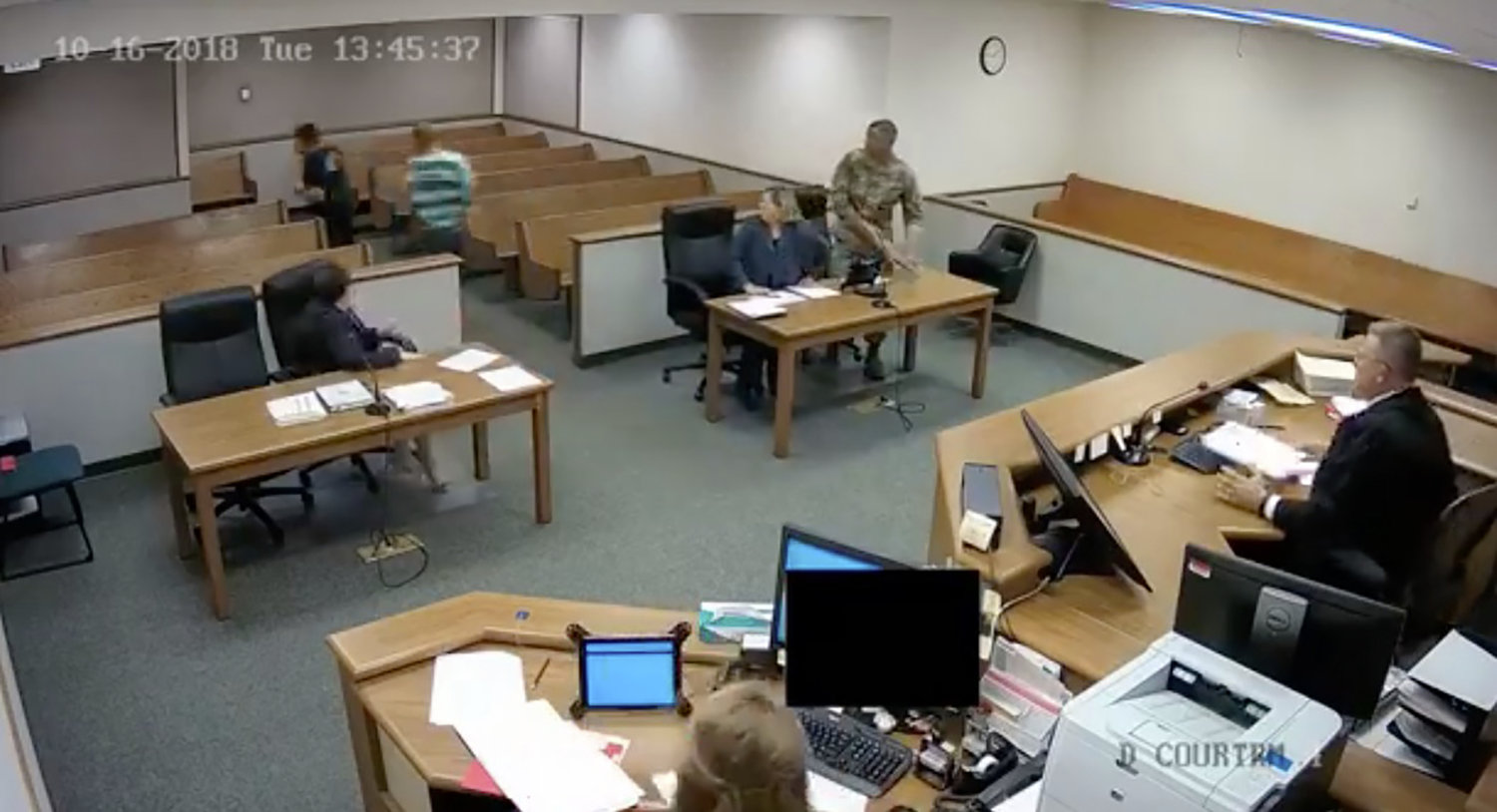 In this screenshot of security footage from the Lewis County Courthouse, Kodey Howard, wearing the solid-colored jail garb, and Tanner Jacobson, wearing the striped jail garb, make a run for the door in Lewis County District Court.