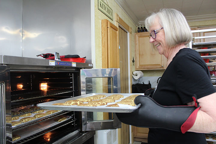 Susy Carpenter puts a tray of oatmeal cookies into the oven for an order for Pacific Northwest Cookie Company. The company began making traditional cookies but after numerous customer requests turned their eyes toward creating a gluten free cookie using no animal products that truly tasted like a more traditional cookies.