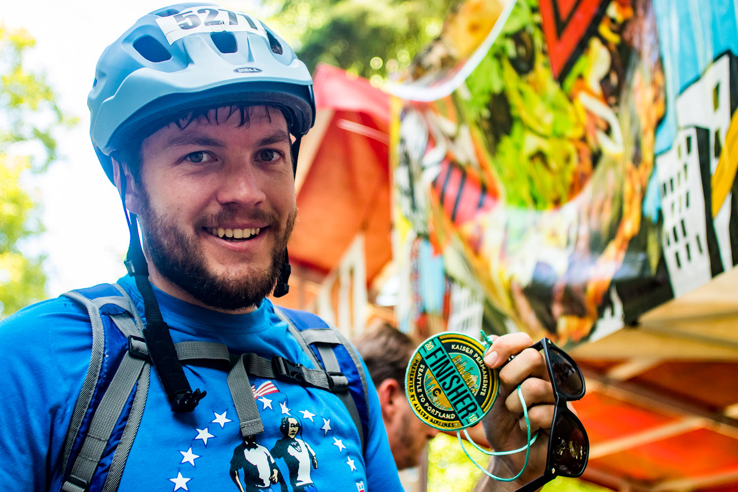 Reporter Alex Brown poses for a photo with his finisher medallion Sunday afternoon at Holladay Park in Portland, Oregon.