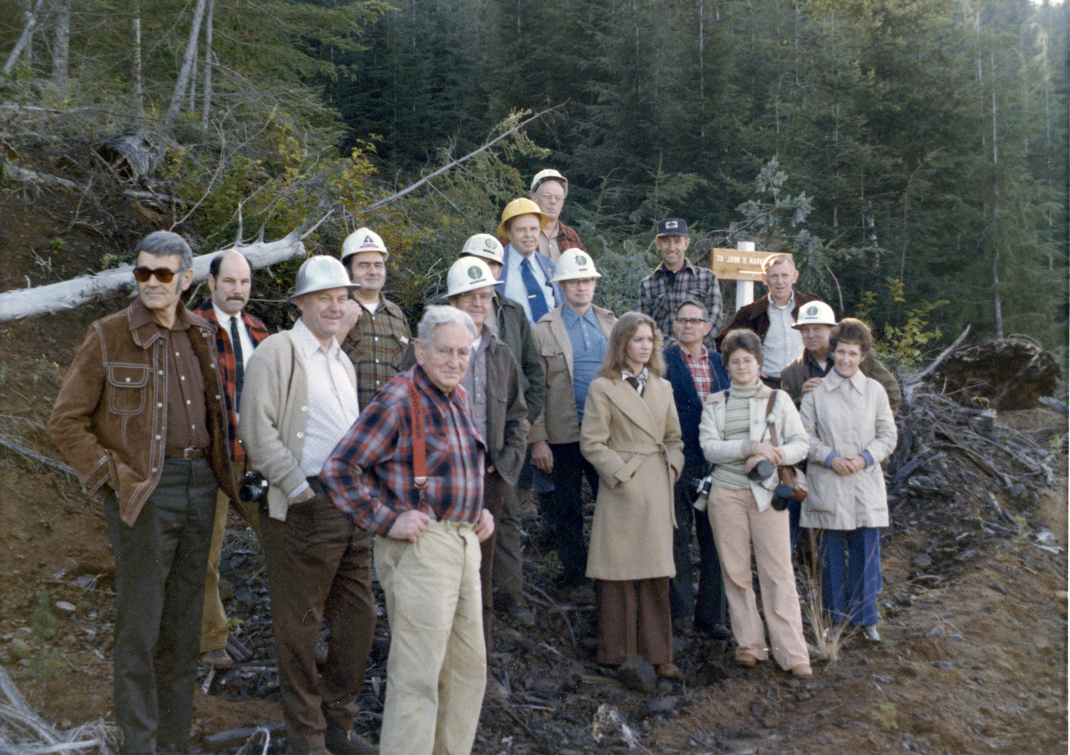 In 1976, at far left is Howard Hopkins of the DNR with John Alexander in back next to him. At front is John Markham. Also shown are Merle Stratton of the DNR, Jim Church of Weyerhaeuser, Bud Clark of the DNR, and Paul Hayes in the cap standing next to the John Markham Tree sign.   