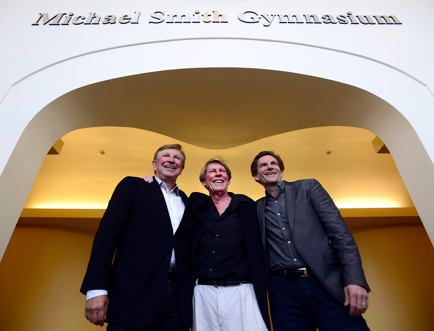 Brothers Orin Smith, Michael Smith and Kevin Smith pose for a picture under the entrance to the renamed Michael Smith Gymnasium at Centralia College in this Chronicle file photo. 
