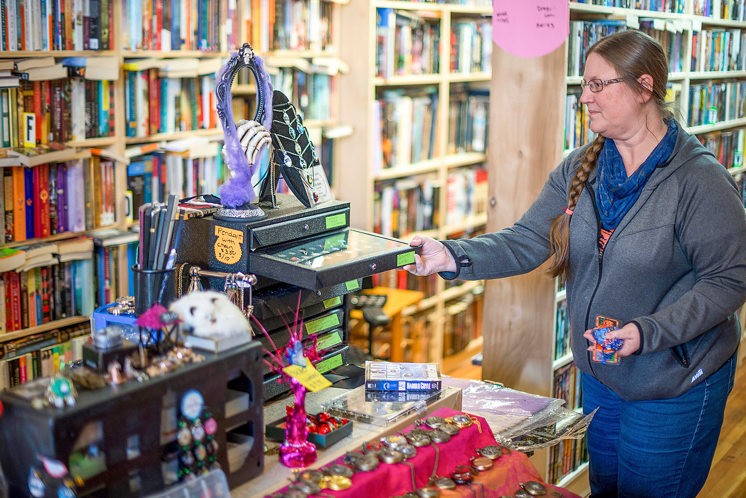 Anderson Book Company owner LaRae Roe shows off some of the other items she has for sale, including charms and pocket watches.