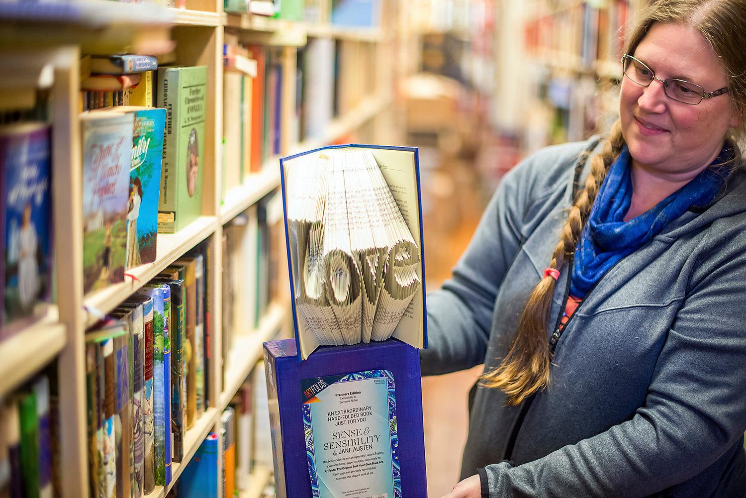ABC Books owner LaRae Roe holds up a copy of “Sense and Sensibility” with its pages folded to spell the word love.