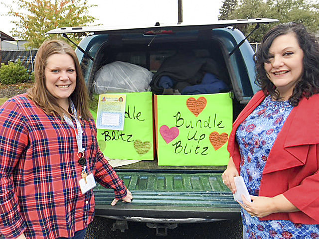 Sarah Kimball, left, from Cascade Mental Health, accepts the donation of coats and winter clothes from Diane Weiner, who organized the annual Bundle Up Blitz held by the Lewis County Chapter of the Washington Realtors Association earlier this month.