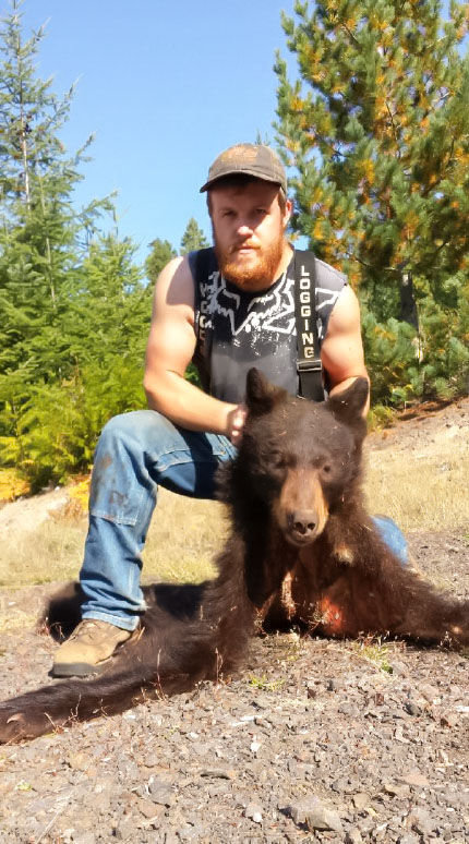 William Haynes poses with the head and hide of a black bear that he allegedly poached with the use of hound dogs near FS 9085 on Sep. 12, 2015.