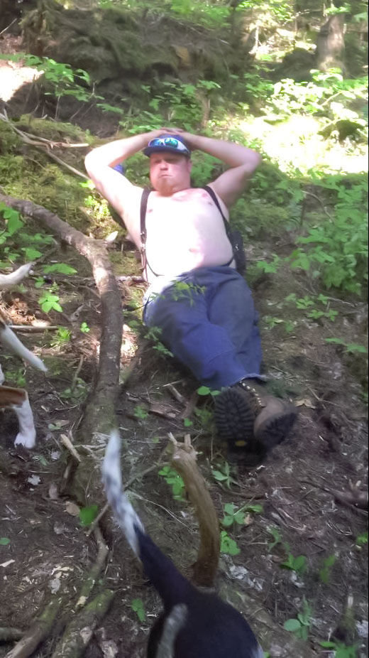 Joseph Dills takes a break in the woods as his dogs finish off a fresh black bear kill outside Randle.