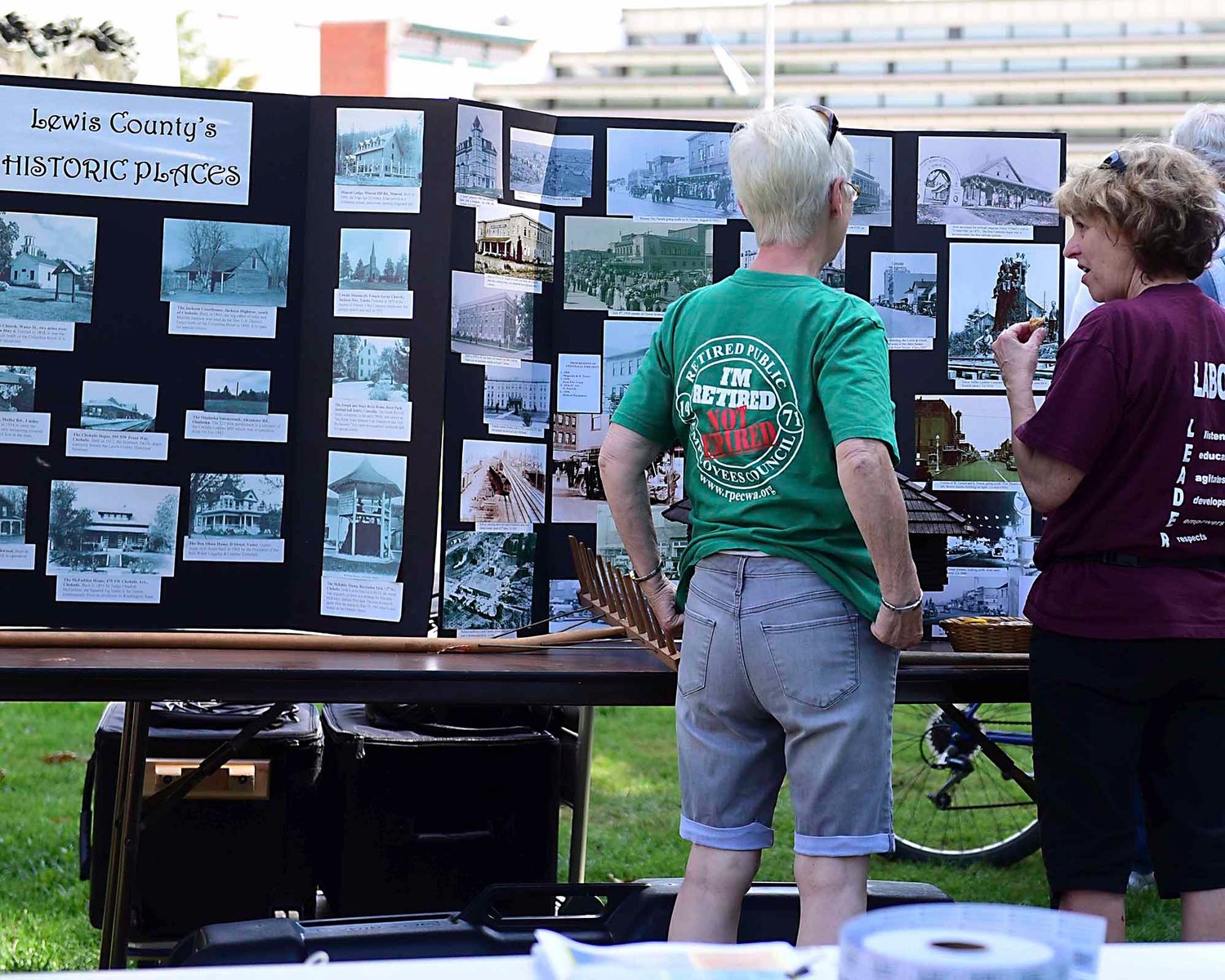 Attendees of the Thurston-Lewis-Mason Labor Council Labor Day Picnic look at a display of historic locations in Lewis County. The picnic included food, activities for children, music, historical displays and information about Centralia founder George Washington.