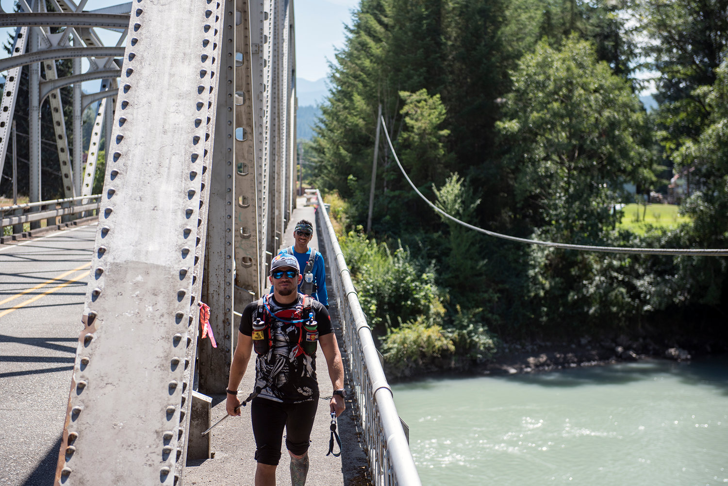 Lucas Rivers (front) and Alfonso Juarez cross the Highway 131 Bridge into Randle on Tuesday as they finished the final few miles of their 206.5 mile journey in the Bigfoot 200 race.