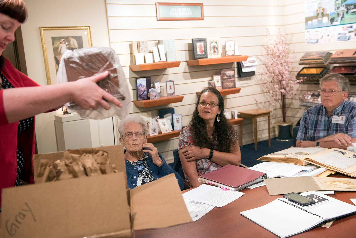 Jeanne Louvier, left-center, her daughter, Jan Bradshaw, and son-in-law Tom Bradshaw look on Malynda Wilson, left, the intern funeral director at Brown Mortuary Service, unpacks the urn that will hold the remains of William "Bill" James Gray, Jr., Louvier’s brother, on Friday, July 7, 2017, in Centralia. Army Air Force 1st Lt. William “Bill” James Gray, Jr. died while serving in Germany on April 16, 1945. The Defense POW/MIA Accounting Agency recently accounted for his remains. He will be buried on Friday, July 14, at Tahoma National Cemetery in Kent, Wash.