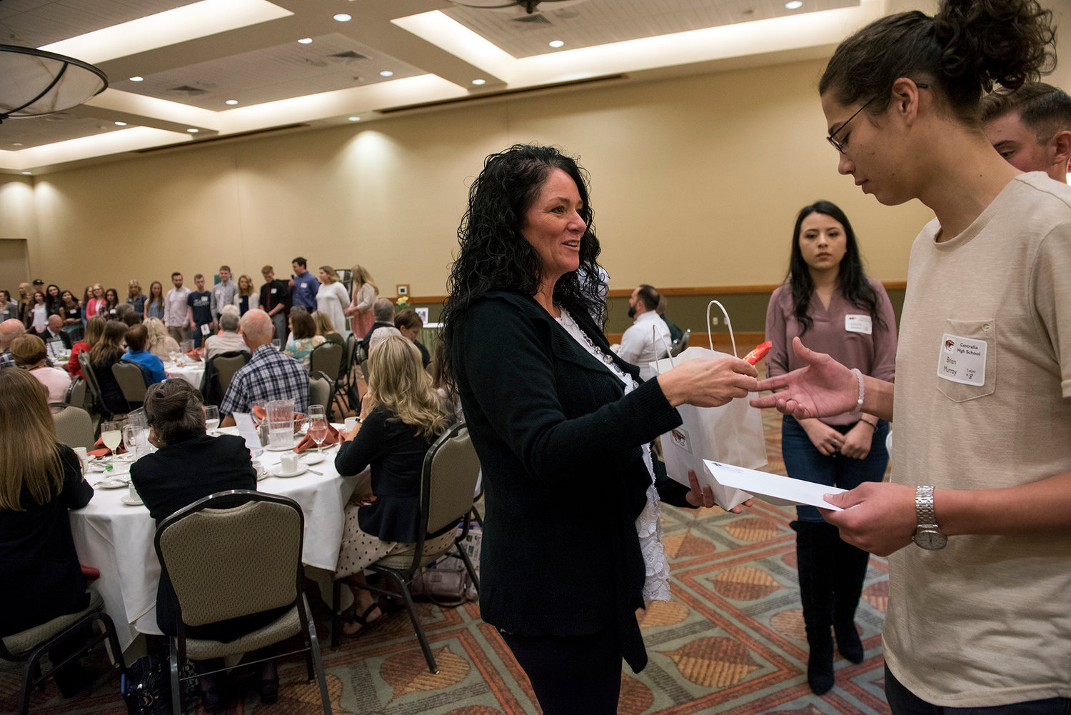 The top 25 students from Centralia High School are handed gift bags and their "first 100 Grand" according to Alicia Bull, the Centralia-Chehalis Chamber of Commerce executive director and the emcee of the Rob Fuller Scholarship Lunch at the Great Wolf Lodge in Grand Mound on Monday, May 8, 2017.