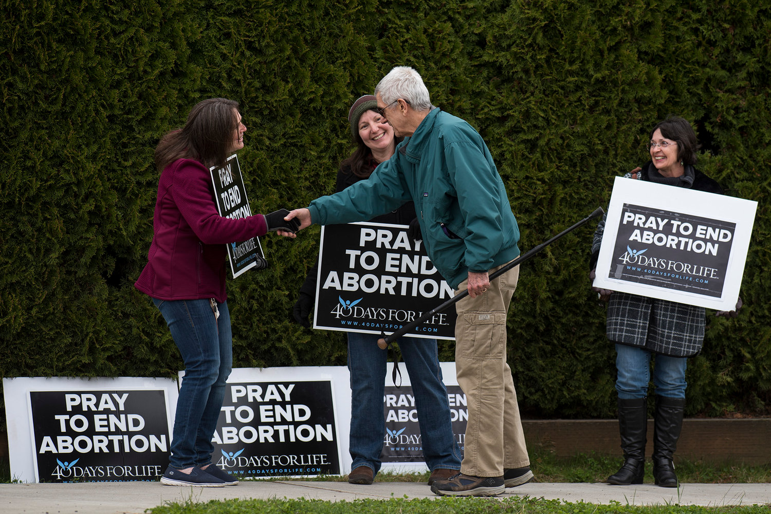 Laurie Robbins, of Centralia, left, greets Nick Radovcich, of Onalaska, as Karen Maxwell, left-center, of Centralia, and ida Clary, Evaline, look on as they participate in the 40 Days for Life prayer vigil outside the Centralia Planned Parenthood on Monday afternoon.