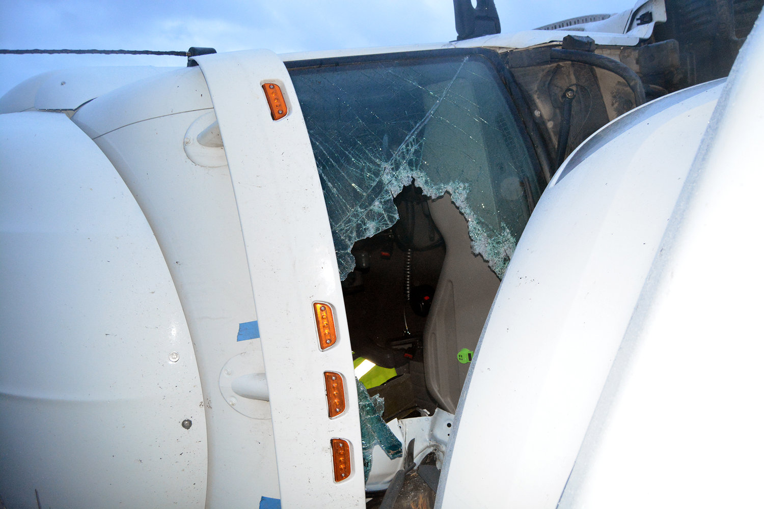 The windshield of a semi truck is broken out after the truck rolled off the shoulder of the northbound lane of Interstate 5 at mile post 76 on Tuesday morning in Chehalis.