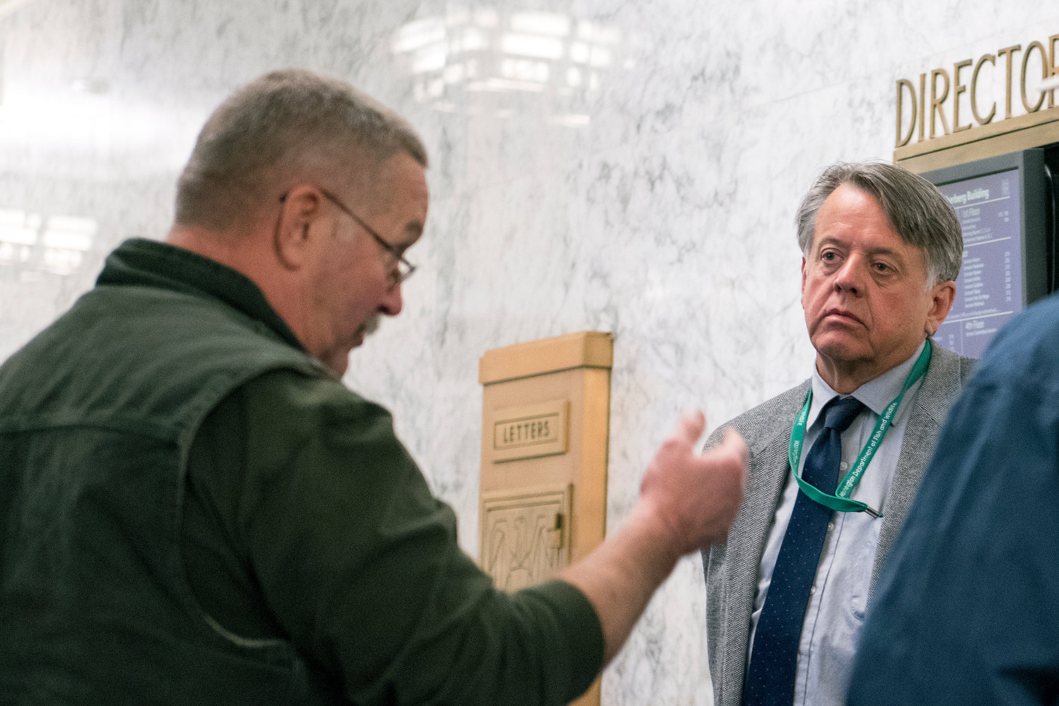 WDFW Director Jim Unsworth listens as a concerned citizen voices his opinions on the lost fish from the Cowlitz Trout Hatchery after a hearing in Olympia on Thursday afternoon.