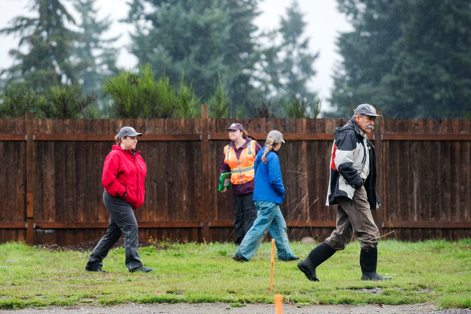Three members of the U.S. Fish and Wildlife along with a lone Thurston County employee (safety vest) walk the premises of Chris Weaver's home in Rochester on Thursday during a government mandated pocket gopher search.