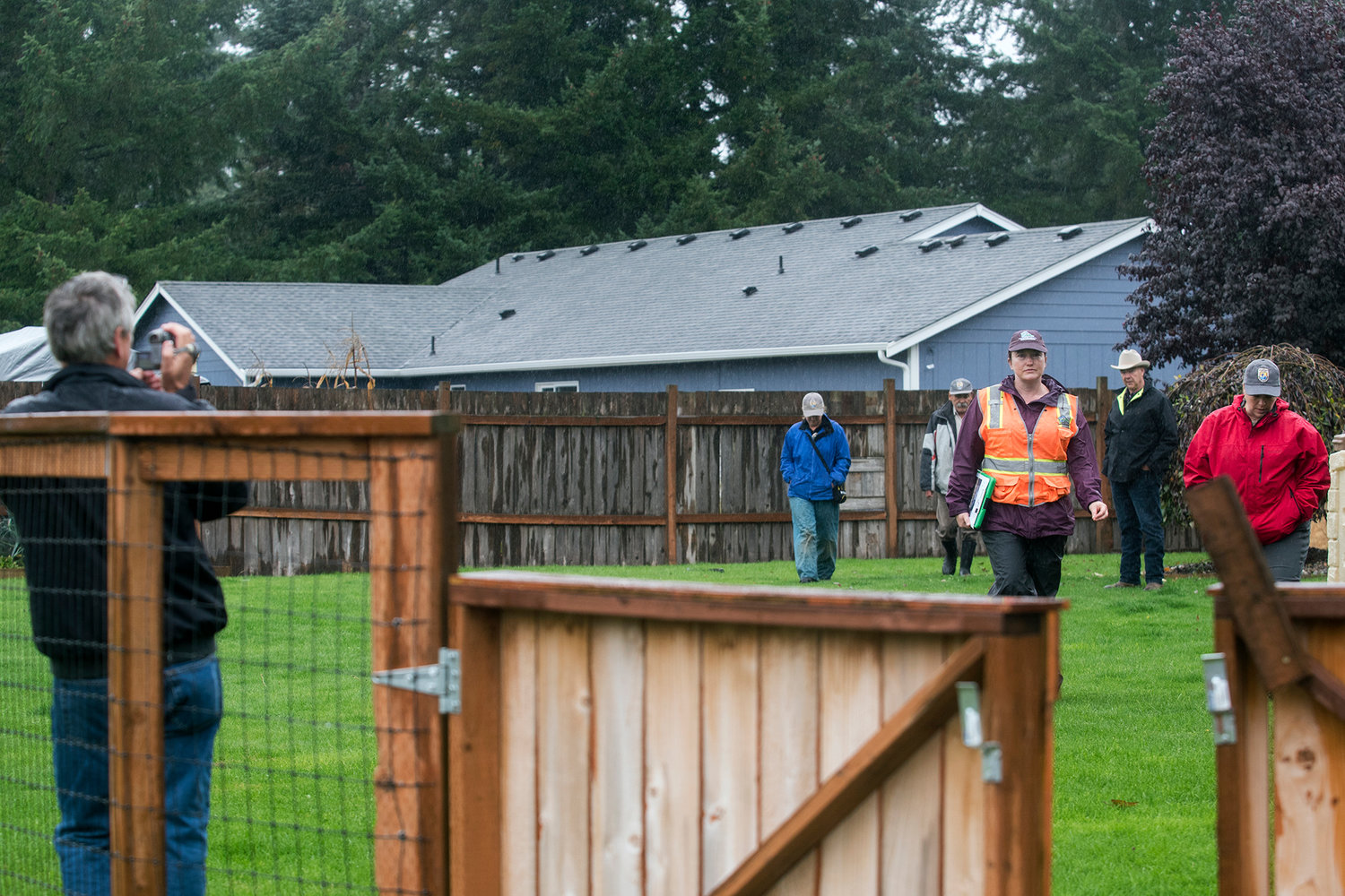 Larry Weaver records the action as Thurston County and federal representatives walk Chris Weaver's property in search of evidence of pocket gophers on Thursday in Rochester.