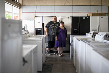 Angie Solis, who owns D.B. Cooper Appliances, and her, husband, Donald Byron Cooper, who does a majority of the maintenance and refurbishing of the appliances pose for a portrait at their downtown Chehalis store on Tuesday afternoon.