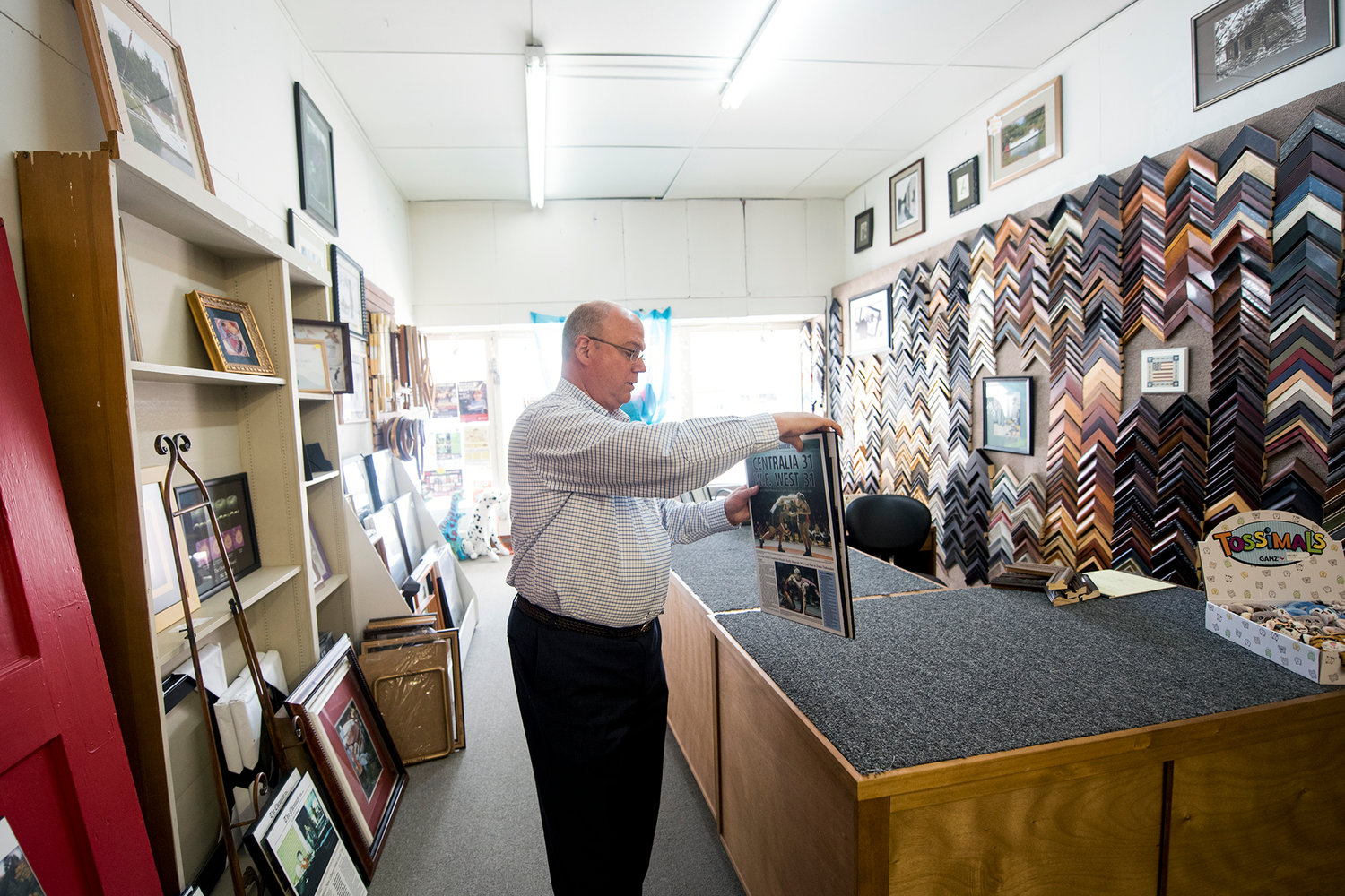 David Hartz, owner of Book 'n' Brush, shows examples of keepsakes that his framing shape produces at his store in downtown Chehalis.